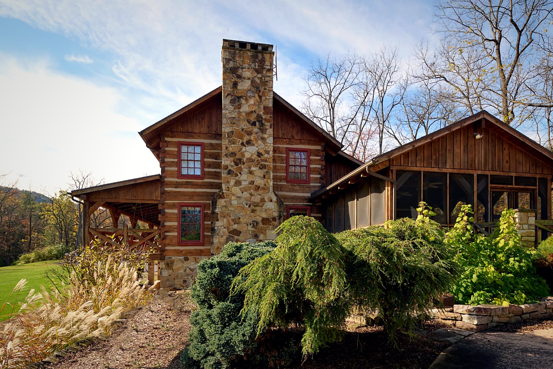 Stacked-stone chimney meeting the screened porch wing