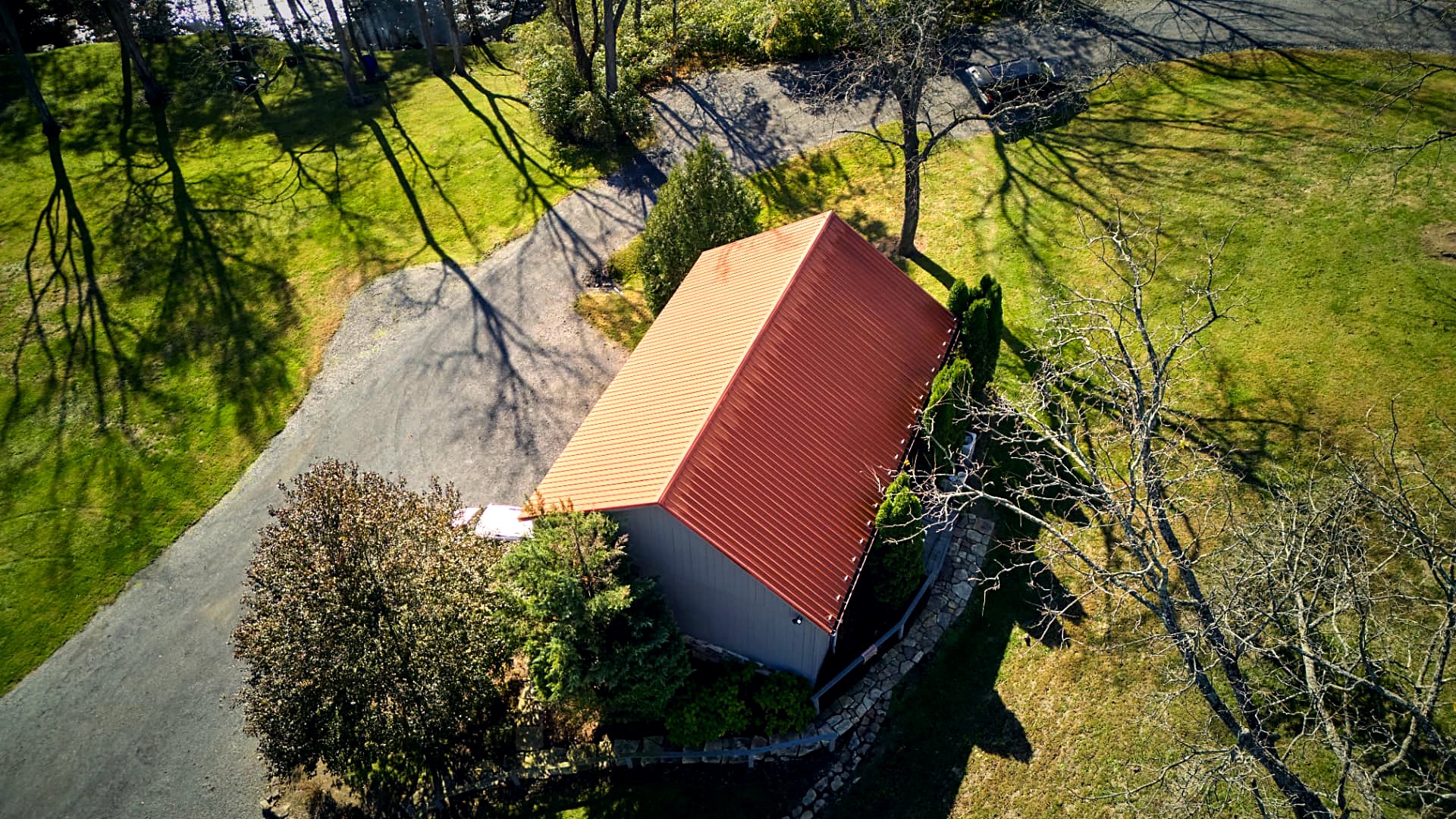Top-down on the barn's ember-red standing-seam roof