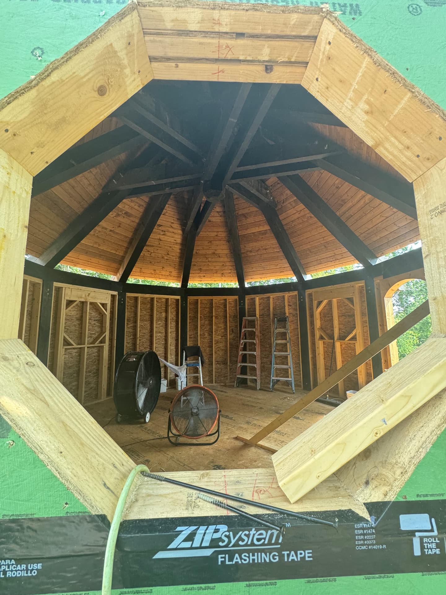 Framed octagonal interior seen through the timber roof opening during construction