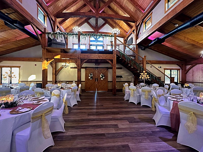 Banquet setup under the timber frame with the balcony stair and gable window behind