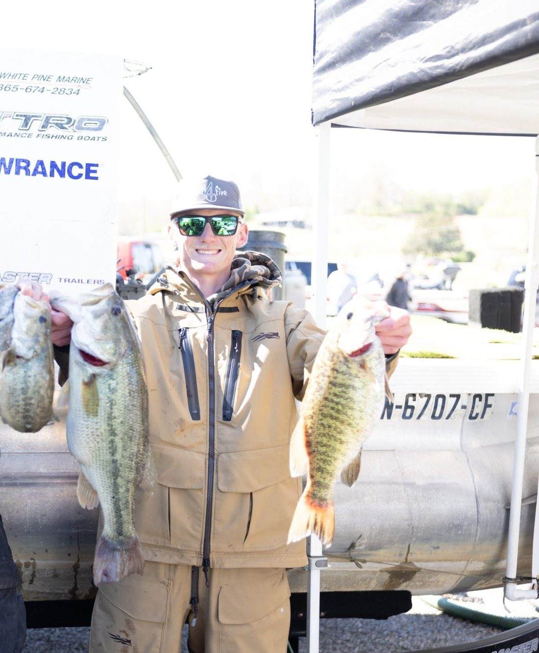 Jack Hall at a 2026 bass tournament weigh-in holding two largemouth bass