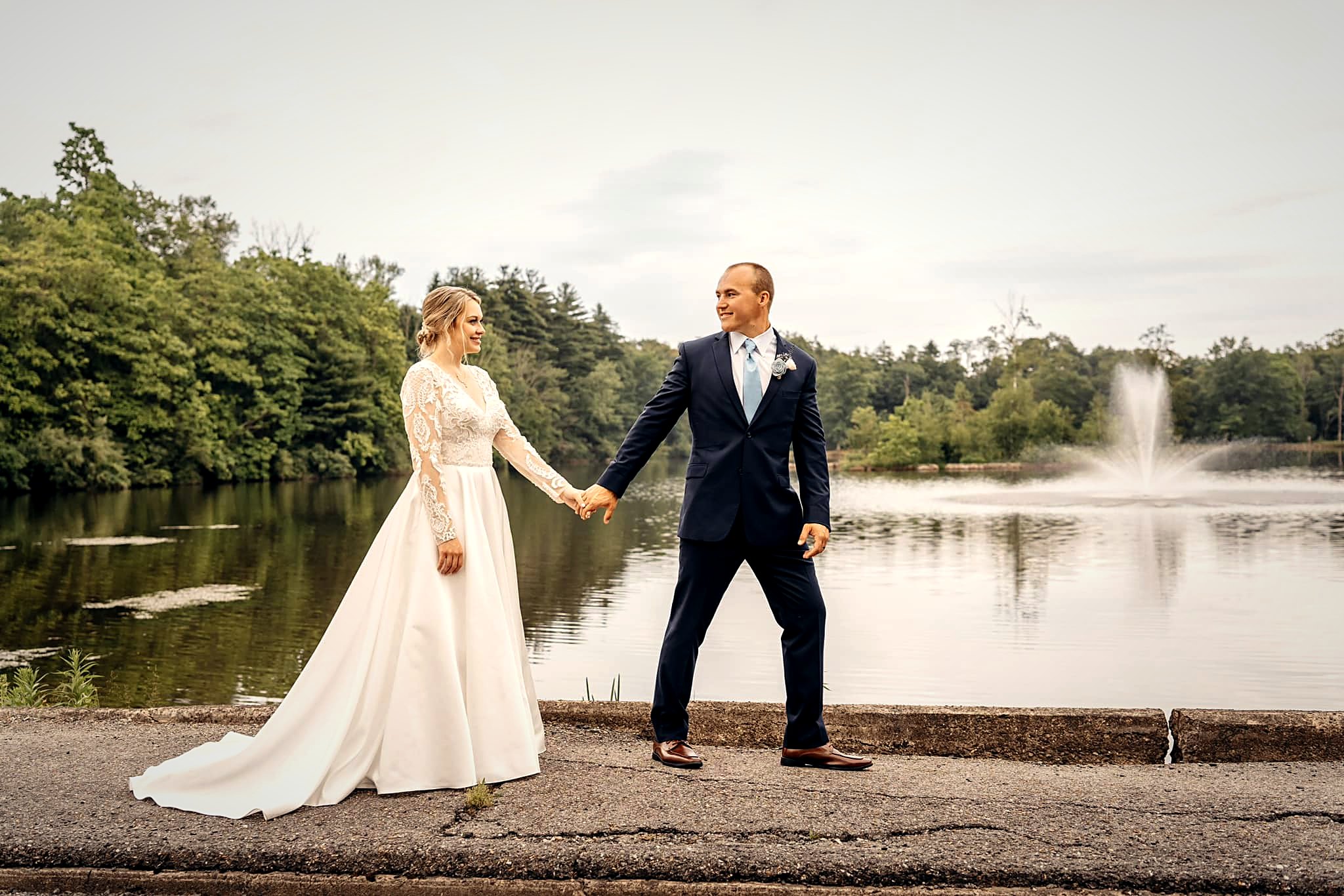 A couple walking the shoreline path with the lake fountain behind them