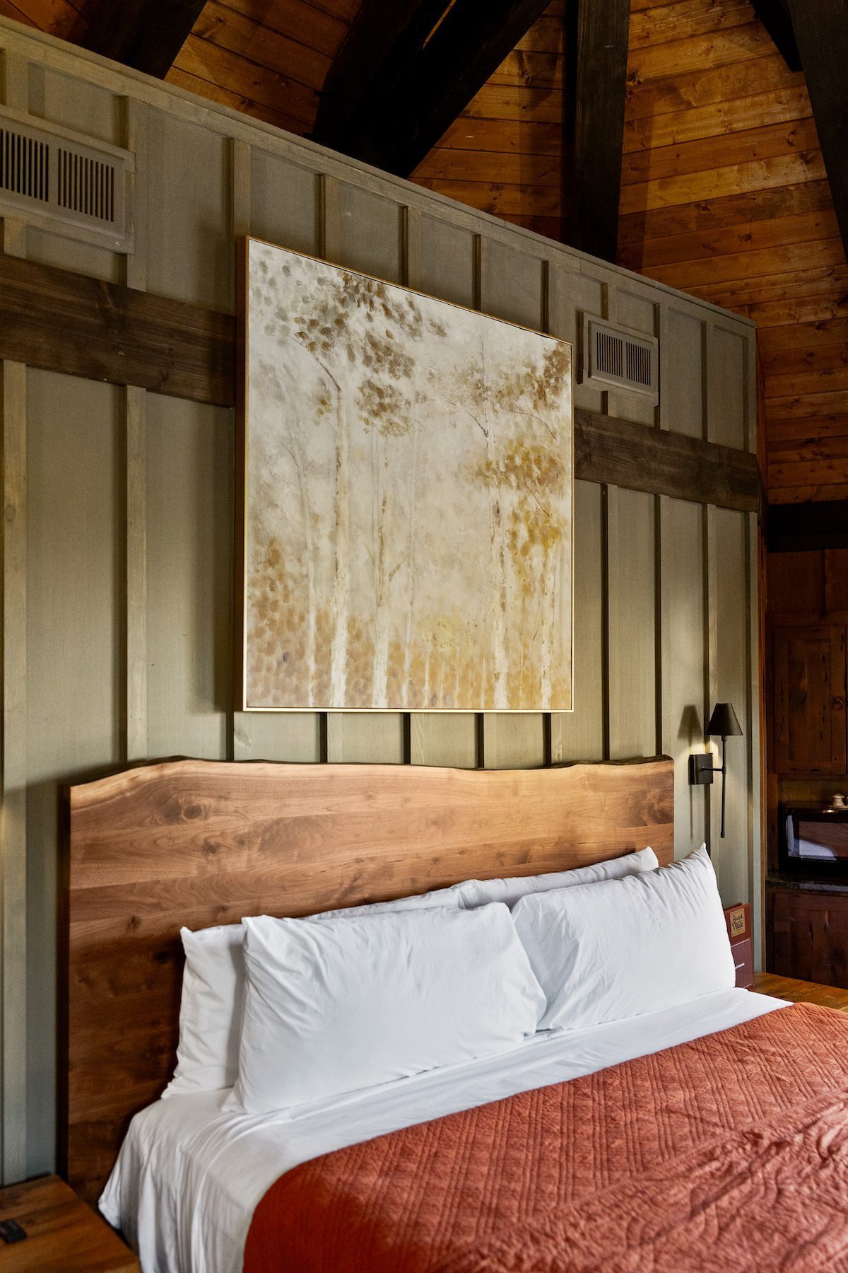 Elven Treehouse bedroom with orange quilt and abstract artwork