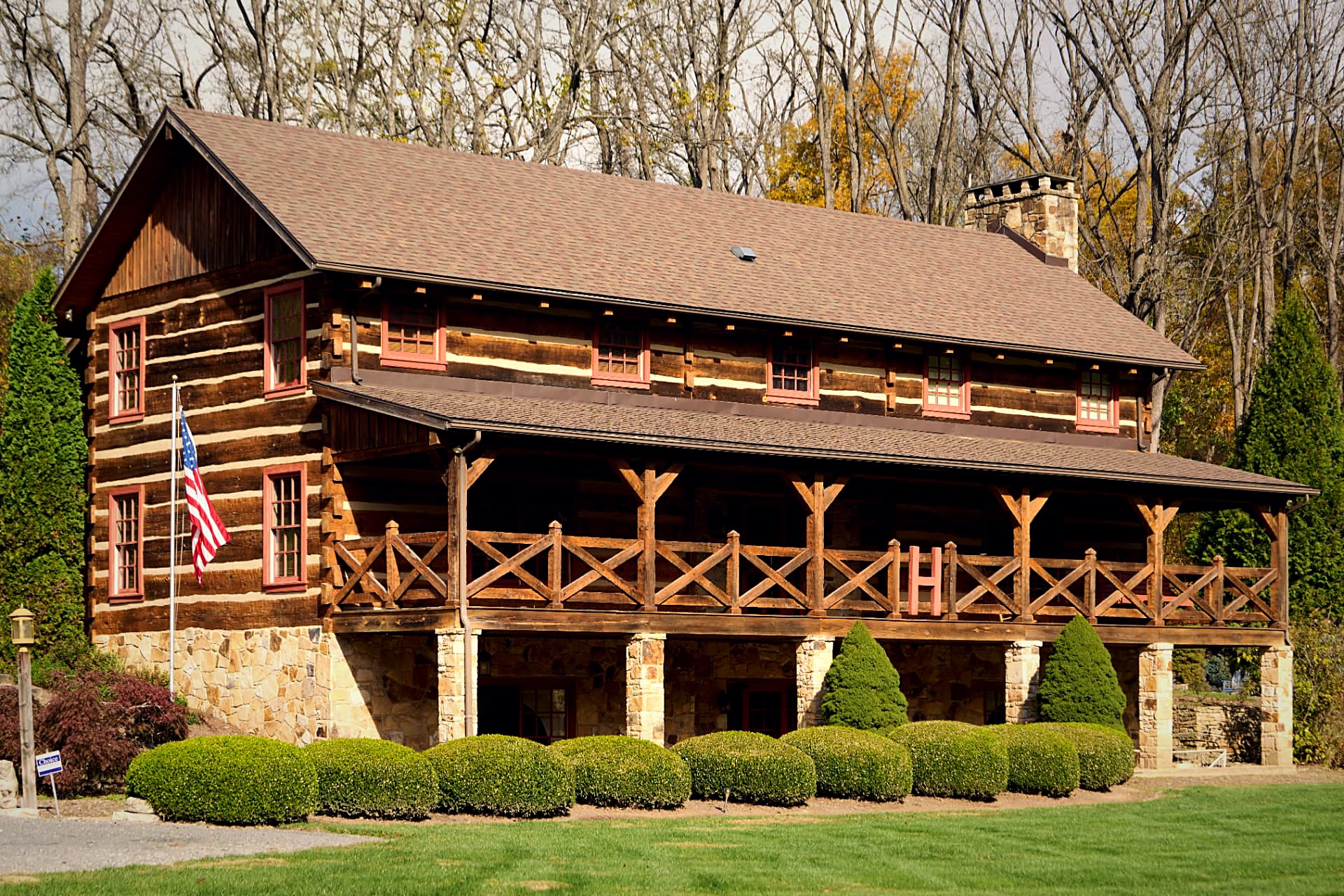 Front elevation with the flag flying and the monogrammed 'H' set into the cross-braced porch railing