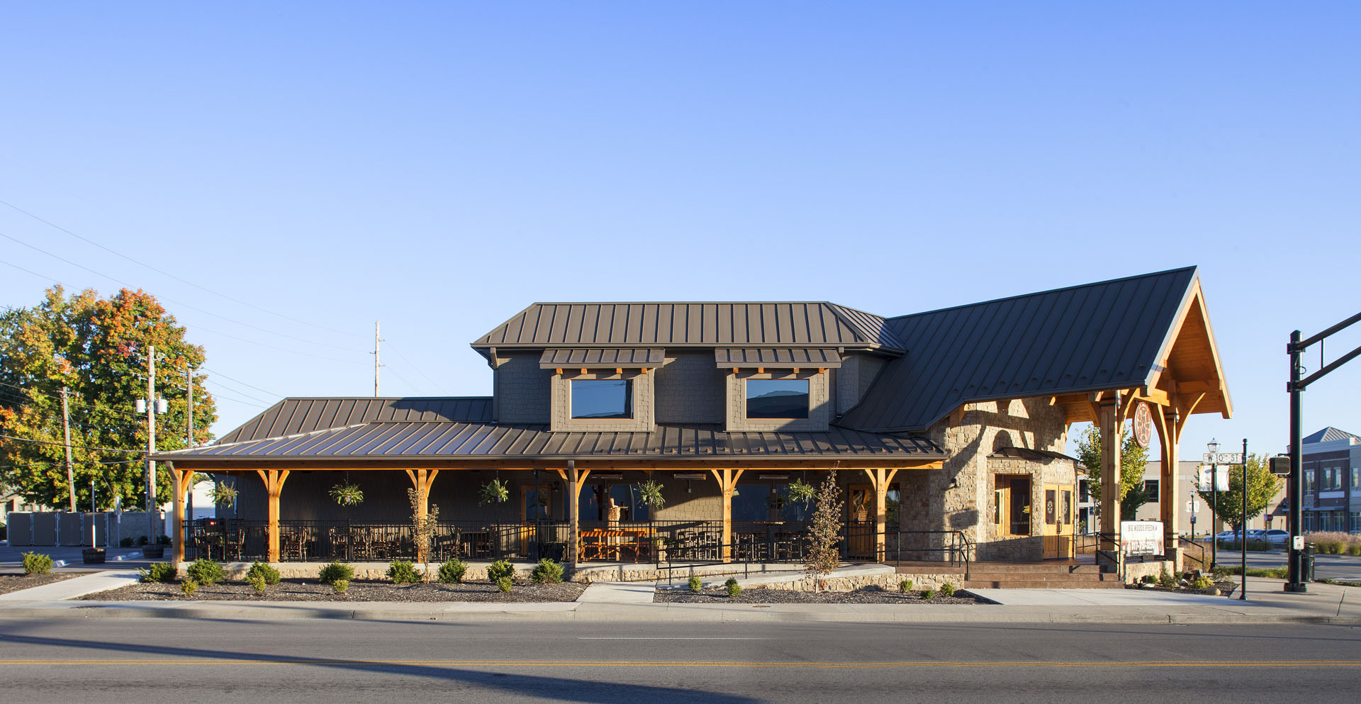 Big Woods Speedway full exterior elevation — long covered timber porch under a standing-seam roof
