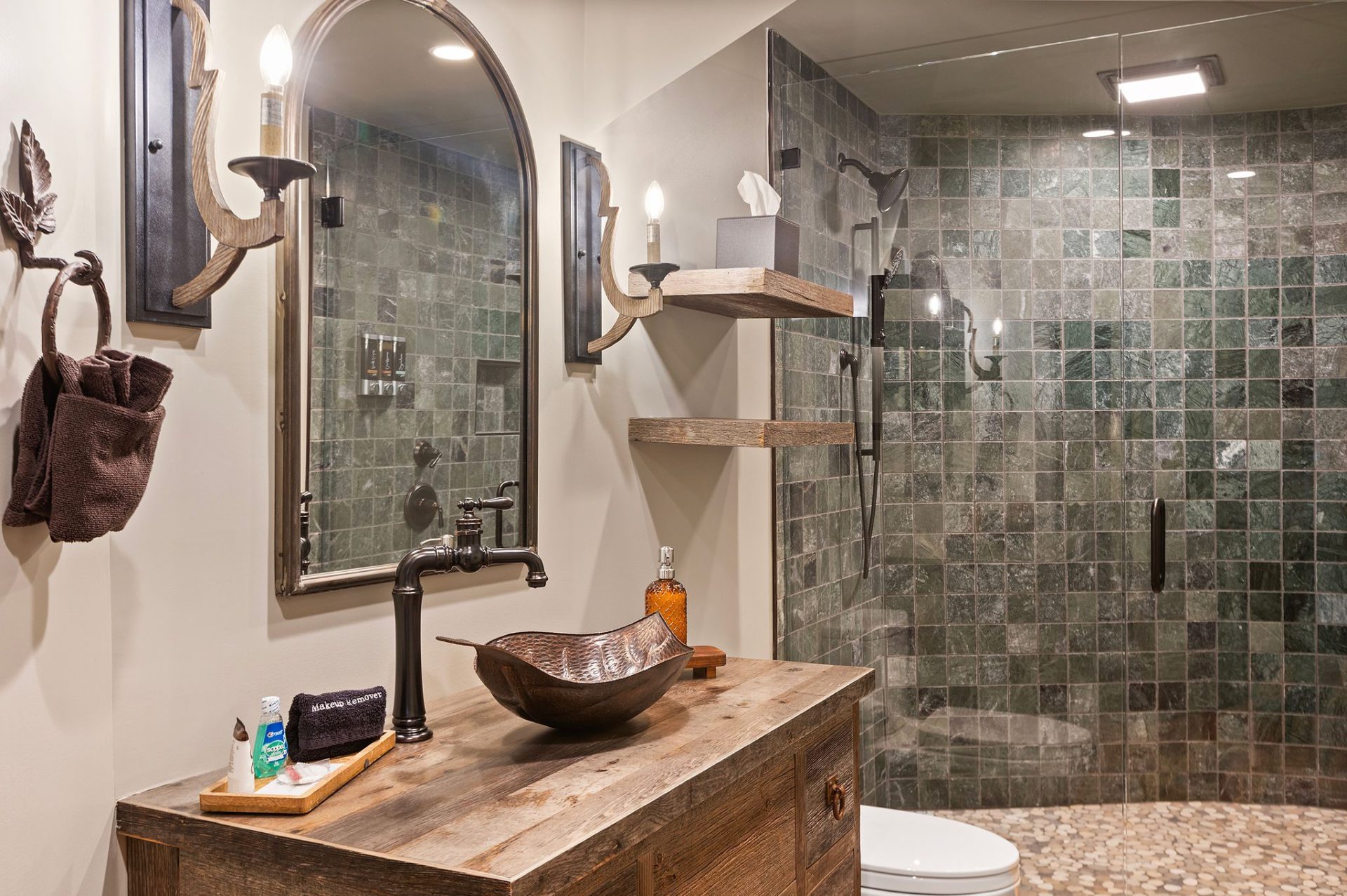 Elven Treehouse bath with live-edge vanity, hammered vessel sink, and green-tiled walk-in shower
