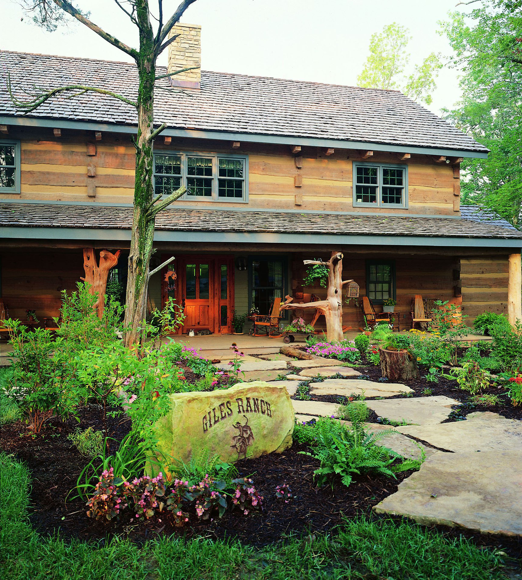 Giles Ranch stone entry marker at the front porch of Hickory Ridge, hewn-log elevation and cedar-shake roof