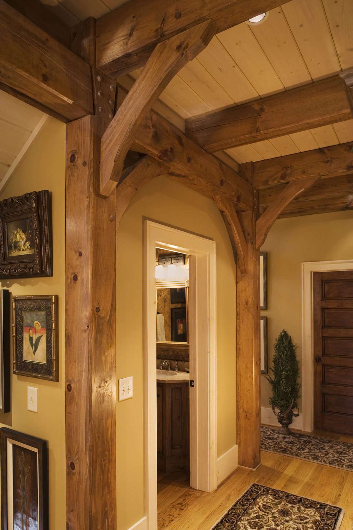 Interior hall detail — chamfered timber post and beam framing the passage to the bedroom wing