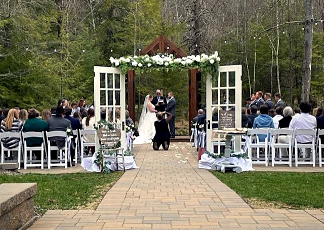 Paired glass entrance doors opening from the ceremony lawn into the timber hall