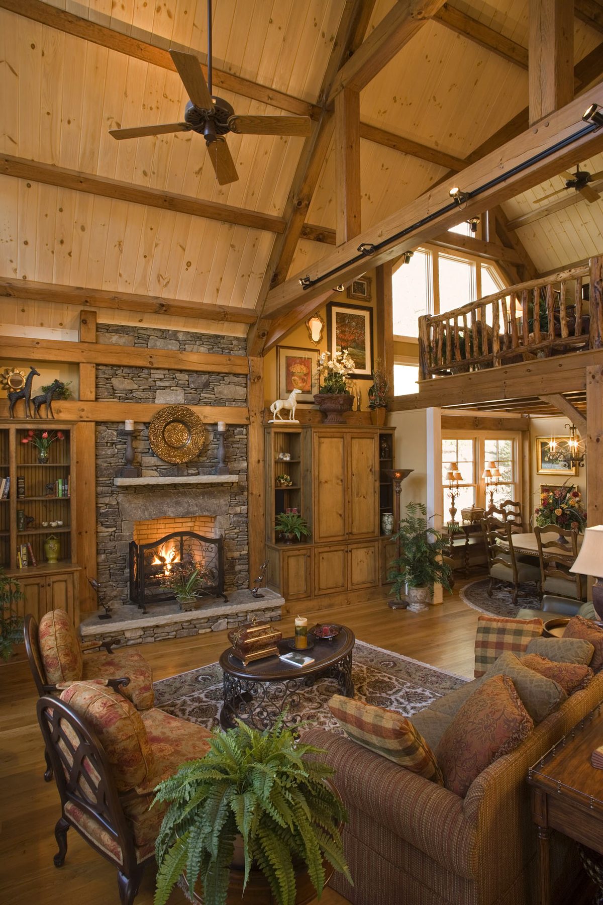 Fieldstone hearth wall of the great room with timber posts and pickled tongue-and-groove ceilings
