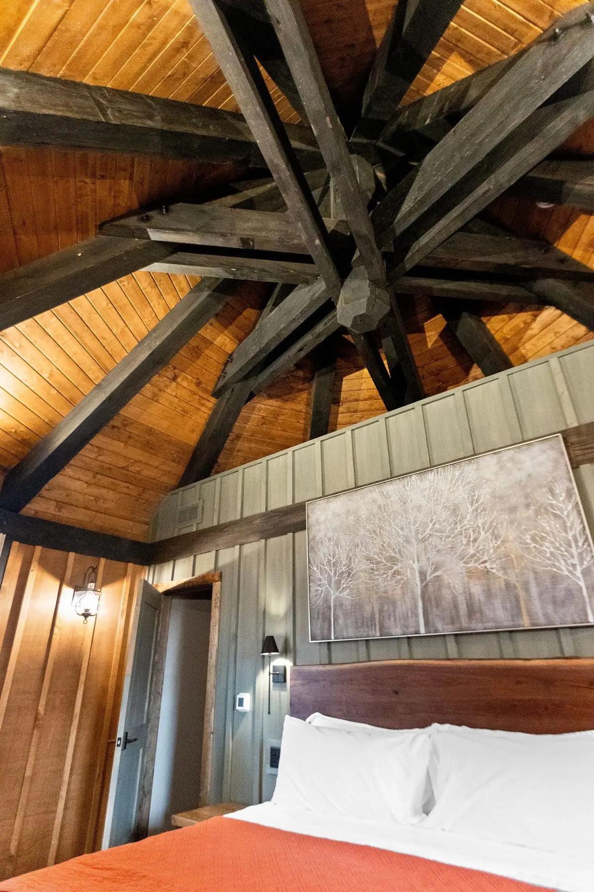 Elven Treehouse loft bedroom beneath a radial hub-and-spoke timber rafter ceiling