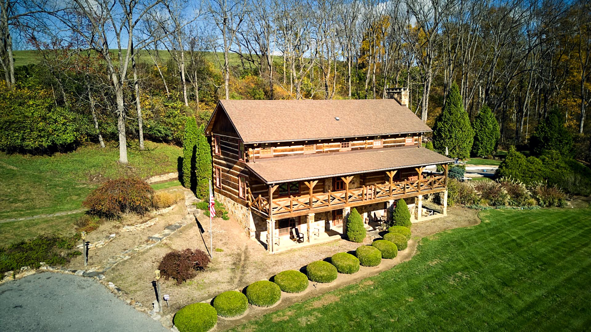The log home with the stone-and-timber guest cabin beyond
