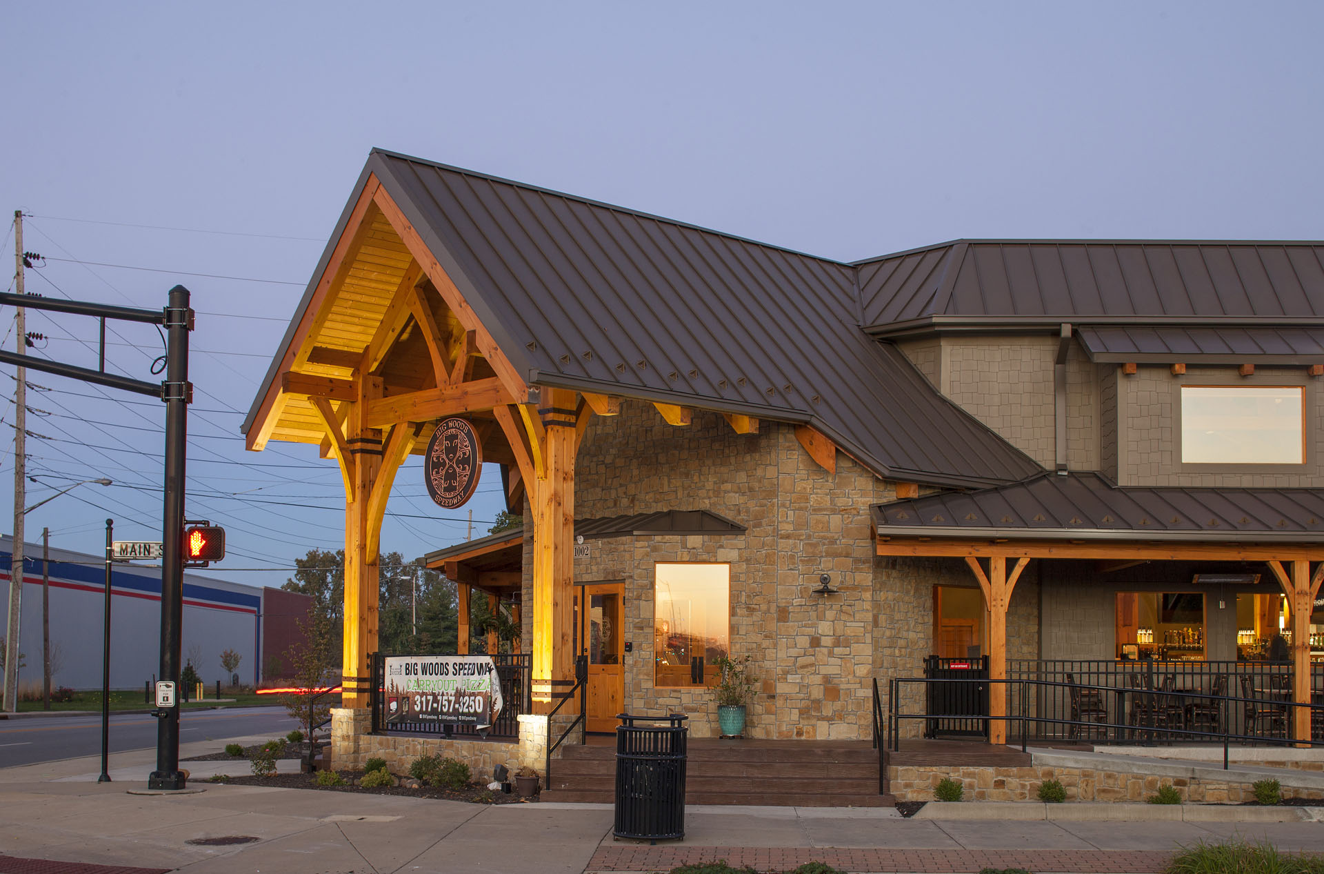Big Woods Speedway entry — timber porte-cochère and stone entry tower