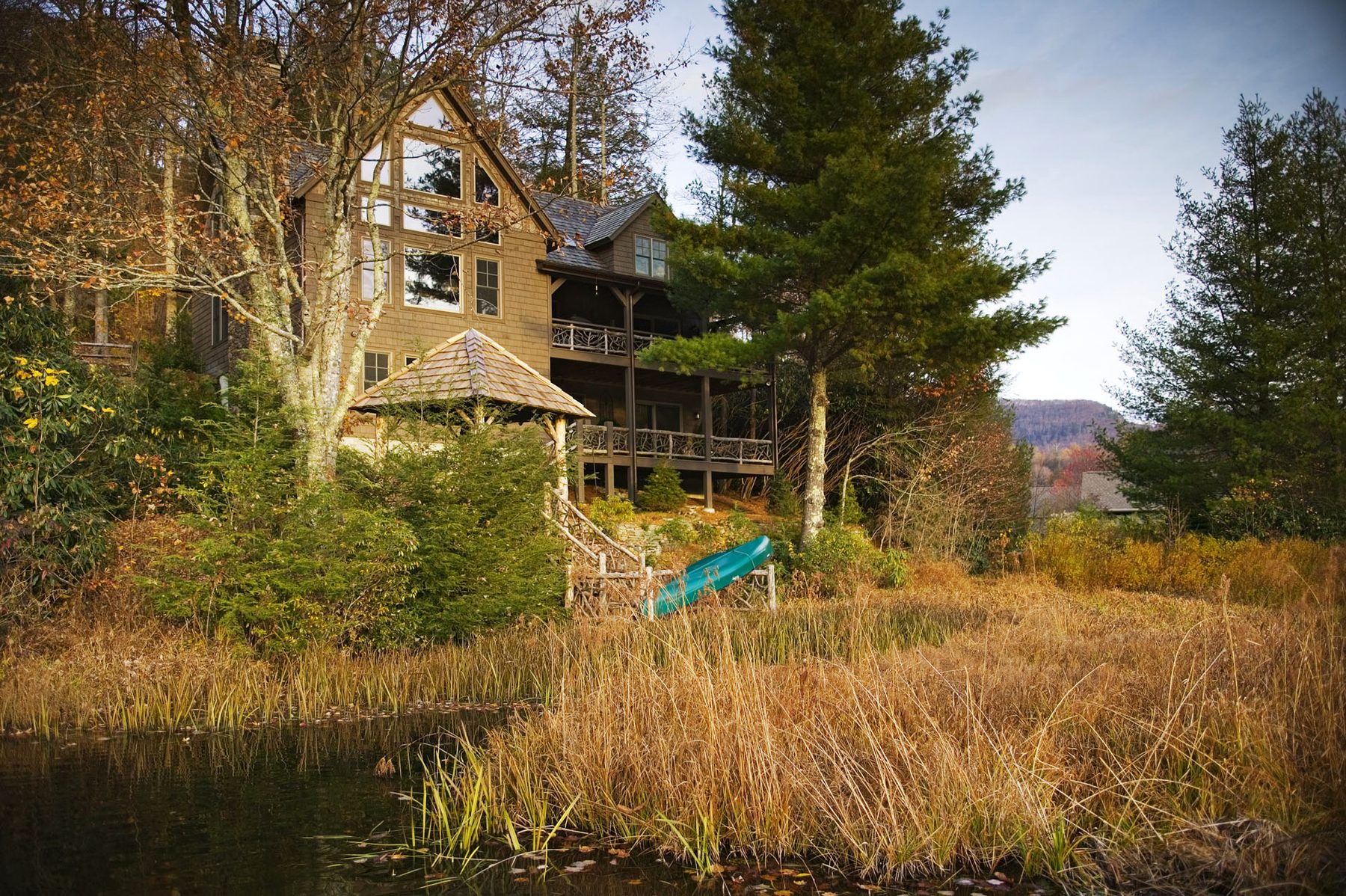 The house above the marsh grass with a canoe drawn up on the shoreline