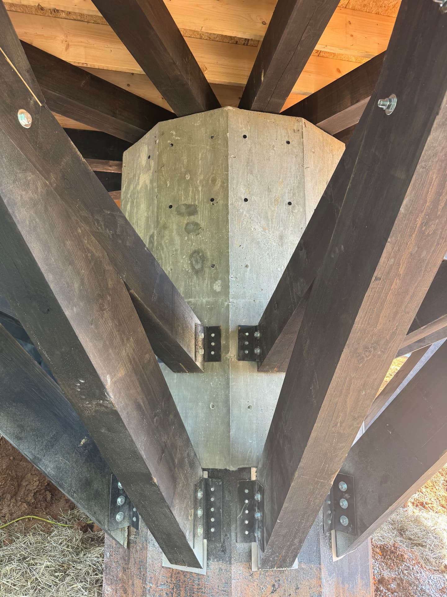 Underside of the treehouse stem post showing radial timber struts and steel connection plates