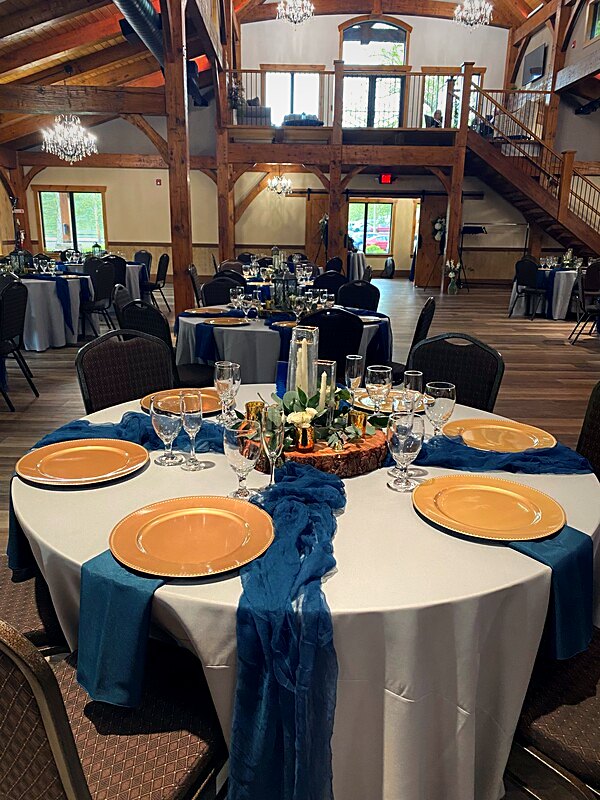 Round tables dressed in linen beneath the timber frame, heated floors underfoot